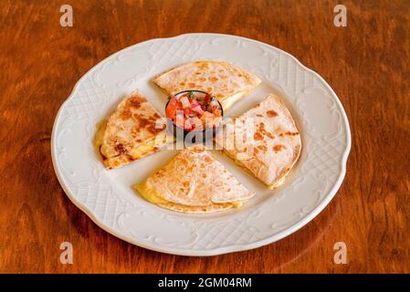 Quesadillas messicano sincronizzato con formaggio fuso e prosciutto con Pico de gallo su tavola di legno Foto Stock