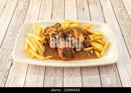 Stufato di coda di bue super tradizionale guarnito con patatine fritte di salsa Foto Stock