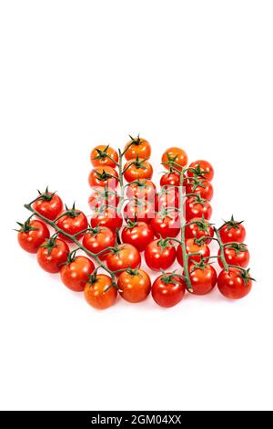 Grappoli di pomodori ciliegini rossi maturi su superficie bianca Foto Stock