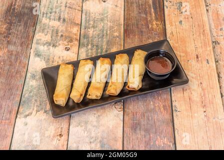 Involtini croccanti ripieni di ricetta di anatra alla pechinese cucinati in un ristorante cinese con salsa d'immersione Foto Stock