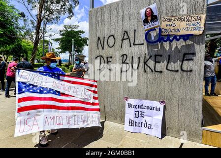 San Salvador, El Salvador. 15 settembre 2021. Un dimostratore detiene una bandiera americana in piedi accanto al Chivo ATM spot con cartelli, durante la protesta. Migliaia di Salvadorans sono scesi per le strade durante la Giornata dell'Indipendenza del Bicentenario di El Salvador contro il presidente di El Salvador Nayib Bukele e le politiche del suo governo. (Foto di Camilo Freedman/SOPA Images/Sipa USA) Credit: Sipa USA/Alamy Live News Foto Stock