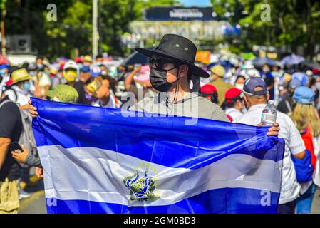 San Salvador, El Salvador. 15 settembre 2021. Un uomo detiene una bandiera di El Salvador durante la protesta. Migliaia di Salvadorans sono scesi per le strade durante la Giornata dell'Indipendenza del Bicentenario di El Salvador contro il presidente di El Salvador Nayib Bukele e le politiche del suo governo. (Foto di Camilo Freedman/SOPA Images/Sipa USA) Credit: Sipa USA/Alamy Live News Foto Stock