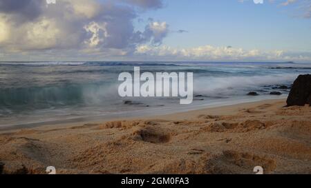 Mattina sulla spiaggia di Poipu a Kauai usando l'esposizione lunga per generare l'effetto lattiginoso sull'acqua dell'Oceano Pacifico. Foto Stock