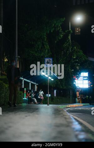 JAKARTA, INDONESIA - 07 luglio 2021: Una stazione degli autobus di notte nella zona SCBD di Jakarta Indonesia con la gente che aspetta l'autobus Foto Stock