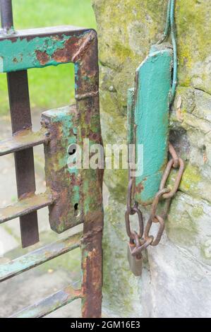 Primo piano di una catena e un wicket di ferro turchese arrugginito Foto Stock