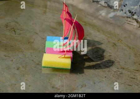 Una linea di quattro navi colorate per bambini in acqua limpida. Giocattolo sai Foto Stock