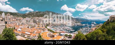 Il Principato di Monaco e Monte Carlo cityscape. Immobiliare di Architettura in montagna collina sullo sfondo. Molti edifici ad alta nell area del centro cittadino. Yacht ormeggiati in città Foto Stock