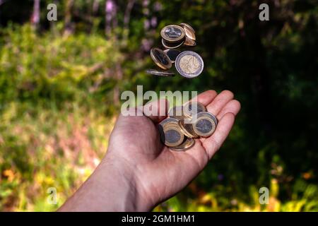 Monete in euro che cadono in mano. Pioggia di denaro. Foto Stock