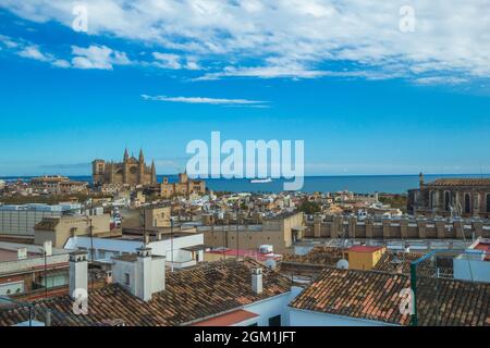 Vista sulla città di Palma di Maiorca con la cattedrale e il mare sullo sfondo. I tetti delle case tradizionali spagnole in primo piano sono incantevoli. Foto Stock