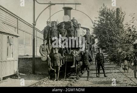 I soldati britannici del corpo degli ingegneri reali si levano in piedi su una locomotiva a vapore, durante o subito dopo la prima guerra mondiale Foto Stock