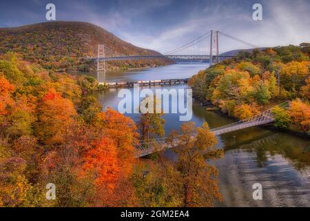 Fall at Bear Mountain Bridge - guardando verso sud al Bear Mountain Bridge, treno CSX che viaggia sul ponte sul fiume Hudson e Popolopen Footbridge Foto Stock