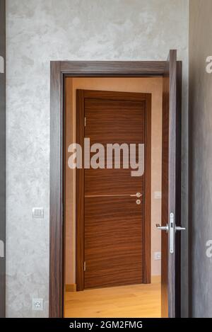 Porta di legno aperta da camera a sala. Interiro moderno di appartamento. Foto Stock