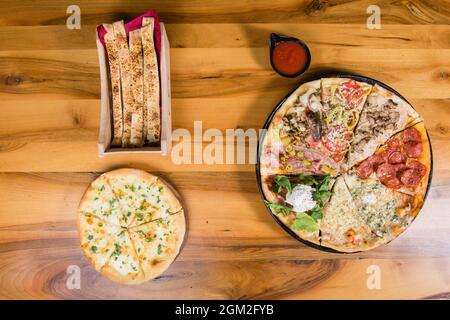 Diversi tipi di pizza combinati in una con salsa di pomodoro, panini e pane per pizza Foto Stock