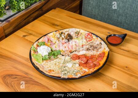 Diversi tipi di pizza combinati in una con salsa di pomodoro, panini e pane per pizza Foto Stock