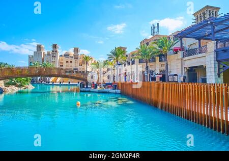 I ponti pedonali sul canale del mercato Souk Madinat Jumeirah, gli edifici tradizionali arabi in vecchio stile con i windcatchers barjeel sono visibili nella Foto Stock