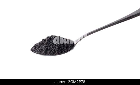 semi neri, noti anche come cumino nero o cumino o kalonji, su un cucchiaio isolato su sfondo bianco Foto Stock