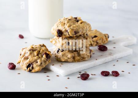 Primo piano di una pila di biscotti fatti in casa per la colazione al lino di mirtilli con una bottiglia di latte. Foto Stock