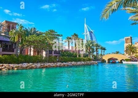 Il mercato del suk Madinat Jumeirah vanta stretti canali con barche da diporto, ponti a piedi e una vista su Burj al Arab, Dubai, Emirati Arabi Uniti Foto Stock