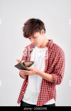 Sono rotto. Ritratto di triste bancarotta asiatica mostrando il suo portafoglio vuoto e guardando la macchina fotografica. Foto Stock