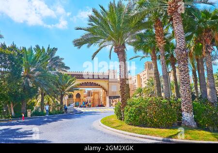 DUBAI, Emirati Arabi Uniti - 4 MARZO 2020: Il giardino ombreggiato verde lungo la strada d'ingresso del mercato Souk Madinat Jumeirah, il 4 marzo a Dubai Foto Stock