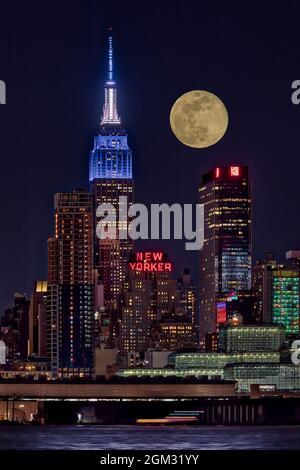 Empire state ESB Super Moon NYC - Vista dell'iconico punto di riferimento urbano dell'Empire state Building illuminato in bianco e blu. Si vede anche il newyorkese Foto Stock