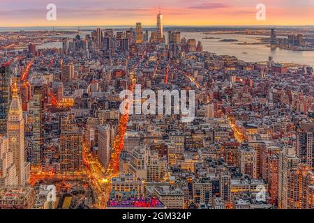 Tramonto aereo di New York - Vista dall'alto dello skyline illuminato di Manhattan inferiore con One World Trade Center WTC (Freedom Tower), Brooklyn, ma Foto Stock