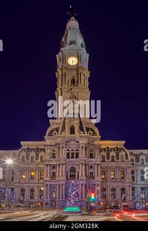 Philadelphia City Hall - Vista del Municipio illuminato al crepuscolo. La lunga esposizione ha creato percorsi di luce dei veicoli che passano e del co Foto Stock