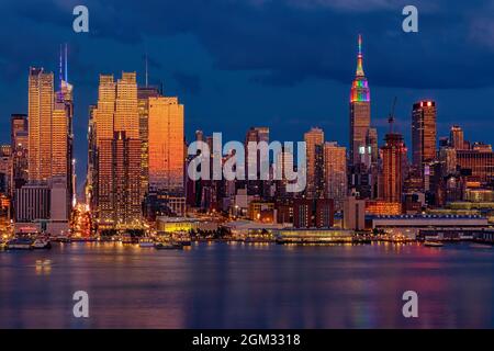 La città di New York skyline orgoglio - Il midtown Manhattan NYC skyline è bagnata con calde e fredde tonalità di colore durante le ore di colore blu al crepuscolo. L'Empire State Foto Stock