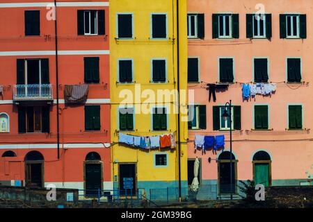 Abitazioni colorate. Sfondo pieno con colorati edifici italiani con abiti appesi. Riomaggiore, Parco Nazionale delle cinque Terre, Italia. Foto Stock