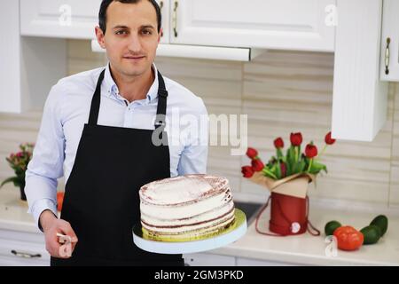 Chef pasticceria di fronte a un banco. Dolci da cucina a casa. L'armeno si dedicò alla pasticceria. Foto Stock