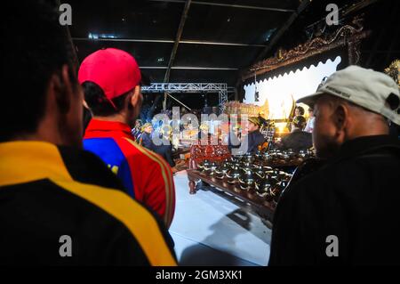 La gente sta guardando un'esibizione di kulit di wayang giavanese. I pupazzi d'ombra sono solitamente in scena dalla sera fino alla mattina presto e sono liberi di essere guardati. Foto Stock