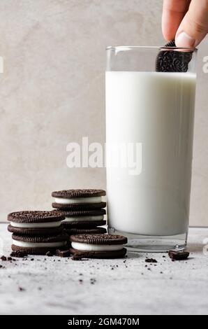 Immergere i biscotti Oreo in un bicchiere di latte Foto Stock