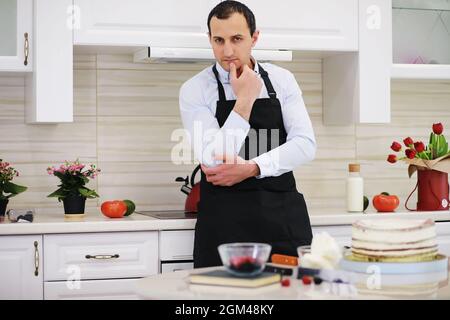 Chef pasticceria di fronte a un banco. Dolci da cucina a casa. L'armeno si dedicò alla pasticceria. Foto Stock