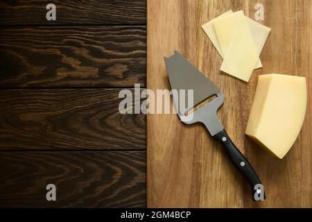 Fette di formaggio parmigiano su un coltello speciale in legno Foto Stock