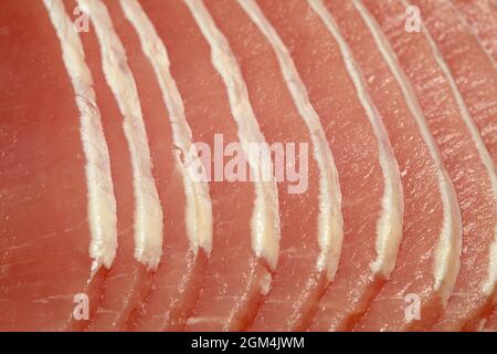 Lombata magra di maiale marinata cruda tagliata a fette sottili con quasi tutto il grasso rifinito Foto Stock