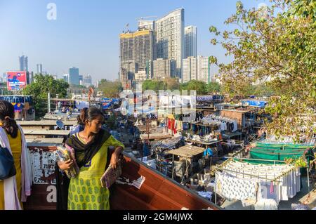 Mumbai, Maharashtra, India : Una giovane donna venditore di souvenir si trova all'accesso al 140-year old Dhobi i Ghat open air lavanderia luogo che si sostiene essere Foto Stock