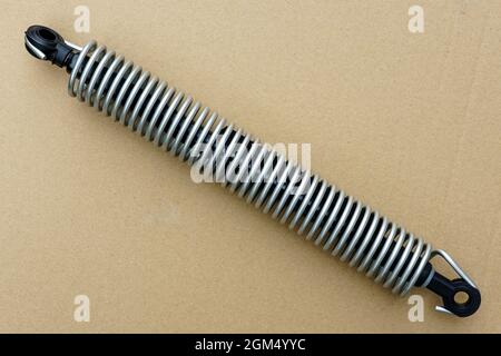 ammortizzatore del cofano e dello sportello del bagagliaio con molla esterna su sfondo di cartone Foto Stock