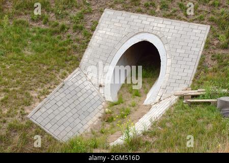 L'uscita del canale di calcestruzzo che scarica l'acqua in eccesso dalla strada. Costruzione dell'autostrada. Foto Stock