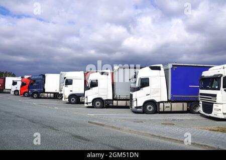 Luogo di riposo. Vari tipi di camion nel parcheggio vicino all'autostrada. Foto Stock