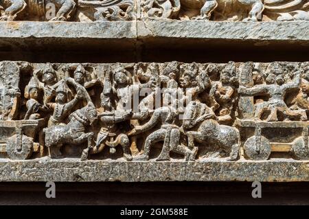 Halebid, Karnataka, India : incisioni sul muro del tempio Hoysaleswara del XII secolo che rappresenta le vittorie dell'Impero Hoysala. Foto Stock