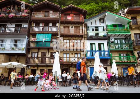 Pasajes, Gipuzkoa, Paesi Baschi, Spagna - 21 luglio 2019 : la gente cammina accanto a case colorate di pescatori nella piazza Santiago di Pasajes de San Juan. Foto Stock