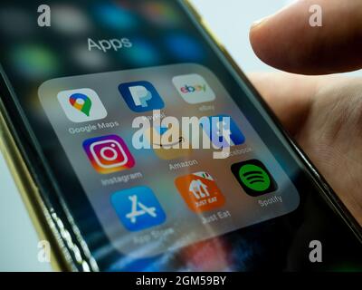 chiudi la mano tenendo un telefono cellulare con una schermata di varie applicazioni Foto Stock
