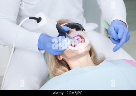 Paziente femmina con i denti scansionati da dentista professionista Foto Stock