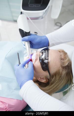 Primo piano verticale di una donna che ha i denti scansionati da un dentista professionista Foto Stock