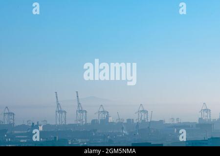 Vista generale del paesaggio urbano con edifici e gru moderni multipli al mattino Foto Stock