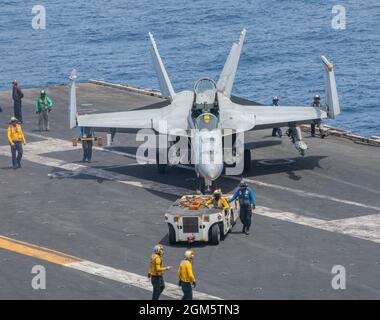 Mar Arabico, Stati Uniti. 29 Agosto 2021. Un jet da caccia Super Hornet della Marina degli Stati Uniti F/A-18F, attaccato ai Royal Macces dello Strike Fighter Squadron 27, viene spostato in posizione sul ponte di volo della portaerei di classe Nimitz USS Ronald Reagan durante le operazioni come ammiraglia della 5a flotta il 29 agosto 2021 nel Mare Arabico. Credit: MC3 Santiago Navarro/Planetpix/Alamy Live News Foto Stock