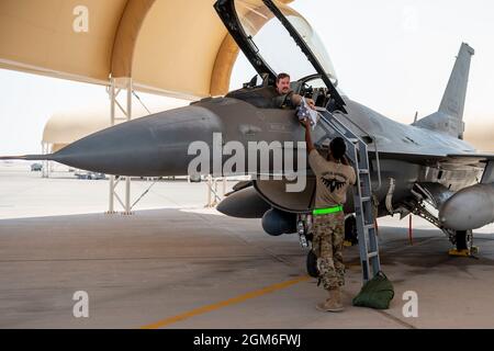 Un capo dell'equipaggio dell'Aeronautica militare statunitense con il 121esimo Squadrone della generazione dei combattenti Expeditionary Fighter consegna una bandiera degli Stati Uniti per essere volato nell'abitacolo di un F-16 Fighting Falcon per pilotare con il 121esimo Squadrone Expeditionary Fighter presso la base aerea Prince Sultan, Regno dell'Arabia Saudita, 27 agosto 2021. Oltre alla logistica e al supporto della forza lavoro, la 378a Ala Air Expeditionary ha fornito Combat airpower per garantire la superiorità aerea del comando Centrale degli Stati Uniti durante le operazioni di evacuazione non combattenti in Afghanistan. (STATI UNITI Air Force foto di staff Sgt. Caleb Pavao) Foto Stock