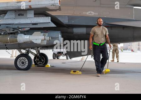 Un capo dell'equipaggio dell'aeronautica degli Stati Uniti con il 121st Expeditionary Fighter Generation Squadron rimuove i cunei dalle ruote di un F-16 Fighting Falcon in preparazione per il taxiing alla base aerea del Principe Sultan, Regno dell'Arabia Saudita, 27 agosto 2021. Oltre alla logistica e al supporto della forza lavoro, la 378a Ala Air Expeditionary ha fornito Combat airpower per garantire la superiorità aerea del comando Centrale degli Stati Uniti durante le operazioni di evacuazione non combattenti in Afghanistan. (STATI UNITI Air Force foto di staff Sgt. Caleb Pavao) Foto Stock