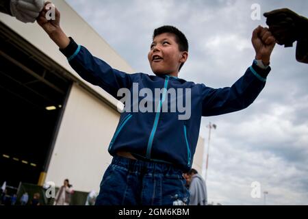 Un bambino afghano dà due soldati assegnati al 1° Battaglione, 6° reggimento di artiglieria da campo, 41° Brigata di artiglieria da campo un pugno di pugni durante l'operazione Rifugio Alleati alla base aerea di Ramstein, Germania, 10 settembre 2021. La base aerea di Ramstein è un centro di transito che fornisce un luogo sicuro per gli evacuati per completare i loro documenti mentre i controlli di sicurezza e di fondo sono condotti prima che continuino verso la loro destinazione finale. (STATI UNITI Foto dell'esercito dello staff Sgt. Thomas Mort) Foto Stock