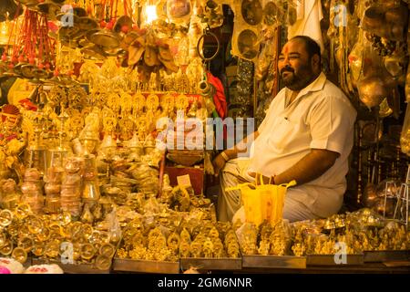 Un negoziante che vende articoli di puja fuori dal famoso e bellissimo tempio di Khandoba a Jejuri durante il festival di Somvati Amavasya Foto Stock